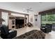 Living room with tile floors, a ceiling fan, a large TV and sliding doors to the outside at 6210 Laurel Creek Trl, Ellenton, FL 34222