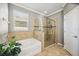 Bright bathroom with a soaking tub, glass-enclosed shower, and large window at 6381 Mighty Eagle Way, Sarasota, FL 34241