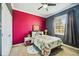 Bedroom features a colorful accent wall, comfortable bed, and a bright, airy window at 6381 Mighty Eagle Way, Sarasota, FL 34241