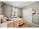 This bedroom has carpet floors, a window, and a white bed with pink linens at 6381 Mighty Eagle Way, Sarasota, FL 34241