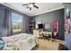 Bedroom features a floral bedspread, gray walls, and large windows for natural light at 6381 Mighty Eagle Way, Sarasota, FL 34241