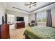 Bedroom featuring a tray ceiling, a desk area with a computer, and a view to the outside at 6381 Mighty Eagle Way, Sarasota, FL 34241