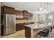 Modern kitchen featuring stainless steel appliances, a granite island, and dark wood cabinetry at 6381 Mighty Eagle Way, Sarasota, FL 34241