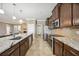 Open kitchen layout with stainless steel appliances, granite countertops, and dark wood cabinets at 6381 Mighty Eagle Way, Sarasota, FL 34241