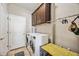 Laundry room features modern washer and dryer, upper cabinets, and tiled flooring at 6381 Mighty Eagle Way, Sarasota, FL 34241
