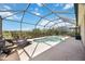Private pool area with lounge chairs, screened enclosure, and serene backyard views at 6381 Mighty Eagle Way, Sarasota, FL 34241