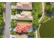 Overhead view of homes with manicured lawns, a tranquil pond, and mature trees in a quiet neighborhood at 6458 Tailfeather Way, Bradenton, FL 34203