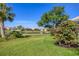 Serene backyard view featuring a tranquil pond, lush greenery, and beautiful landscaping at 6458 Tailfeather Way, Bradenton, FL 34203