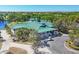 Exterior view of the clubhouse with a green roof, golf carts, and lush landscaping at 6458 Tailfeather Way, Bradenton, FL 34203