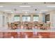 Light and airy clubhouse interior with tables and chairs arranged by windows and light colored walls at 6458 Tailfeather Way, Bradenton, FL 34203