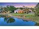 Charming single-story home with a tile roof, landscaped yard, and tranquil pond views at sunset at 6458 Tailfeather Way, Bradenton, FL 34203