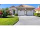 Charming home showcasing a well-manicured lawn, colorful landscaping, and a welcoming entrance with a two-car garage at 6458 Tailfeather Way, Bradenton, FL 34203