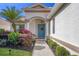 Charming home entrance with a blue front door, lush landscaping, and a well-maintained walkway at 6458 Tailfeather Way, Bradenton, FL 34203