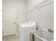 Functional laundry room features modern appliances, a utility sink, and storage shelving at 6458 Tailfeather Way, Bradenton, FL 34203