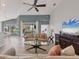 Bright living room with ceiling fan, neutral tones, and sliding doors to the outside at 6458 Tailfeather Way, Bradenton, FL 34203
