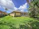 Lush backyard featuring a screened-in patio, bordered by vibrant plants and a well-manicured lawn at 686 Silk Oak Dr, Venice, FL 34293