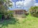 Beautiful backyard featuring a screened lanai, lush green lawn, and tropical palm trees, perfect for outdoor relaxation at 686 Silk Oak Dr, Venice, FL 34293