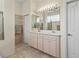 Bright bathroom with double sinks, tile flooring, and a shower provides a functional design at 686 Silk Oak Dr, Venice, FL 34293