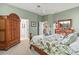 Inviting bedroom featuring a patterned bedspread, complemented by wood furniture and soothing green walls at 686 Silk Oak Dr, Venice, FL 34293