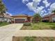 Lovely single-story home with a well-manicured lawn, palm trees, and a driveway under a bright blue sky at 686 Silk Oak Dr, Venice, FL 34293