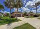 Charming single-story home with well-manicured lawn, driveway and palm trees under a bright blue sky at 686 Silk Oak Dr, Venice, FL 34293