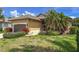 Inviting single-story home with a landscaped lawn, palm trees, and a driveway under a bright blue sky at 686 Silk Oak Dr, Venice, FL 34293
