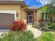 Charming home featuring a walkway leading to a screened front entrance, complemented by colorful landscaping and a brown garage door at 686 Silk Oak Dr, Venice, FL 34293