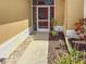 A screened front entrance with a red door, complemented by stone and mulch landscaping at 686 Silk Oak Dr, Venice, FL 34293