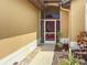 Home exterior featuring a screened front entrance with a bright red door and tidy landscaping at 686 Silk Oak Dr, Venice, FL 34293