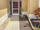 Exterior shot of a screened front entrance with a red door, decorative plants, and exterior lighting at 686 Silk Oak Dr, Venice, FL 34293