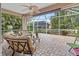 Relaxing screened lanai with comfortable seating and a serene view of the lush backyard at 686 Silk Oak Dr, Venice, FL 34293