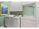 Laundry room with modern appliances, sink, cabinets, and wall art at 686 Silk Oak Dr, Venice, FL 34293