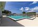Community pool offers a beautiful fenced-in leisure area with water views and a hot tub on a sunny day at 686 Silk Oak Dr, Venice, FL 34293