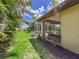 Side yard featuring a screened lanai, lush landscaping, and mulch, perfect for privacy and relaxation at 686 Silk Oak Dr, Venice, FL 34293