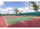 A view of multiple outdoor tennis courts with green and red surfaces, providing ample space for recreational activities at 686 Silk Oak Dr, Venice, FL 34293