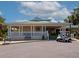 Charming clubhouse with a cozy porch, white railing, and a golf cart parked out front at 7035 Owls Nest Ter, Bradenton, FL 34203