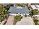 An aerial view of a single-story home featuring a new gray roof and tropical landscaping with palm trees at 711 Birdsong Ln, Sarasota, FL 34242