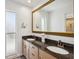 Bathroom featuring a double sink vanity with granite countertop and elegant mirror at 711 Birdsong Ln, Sarasota, FL 34242