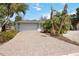 Paver driveway leads to a two-car garage, complemented by lush landscaping at 711 Birdsong Ln, Sarasota, FL 34242