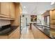 Kitchen featuring stainless steel appliances, granite countertops, tile flooring, and light wood cabinets at 711 Birdsong Ln, Sarasota, FL 34242