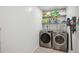 Functional laundry room featuring a washer, dryer, and shelving for storage at 711 Birdsong Ln, Sarasota, FL 34242