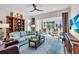Spacious living area with a comfortable seating area, shelving, and sliding glass doors to the exterior at 7116 Drewrys Blf, Bradenton, FL 34203
