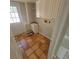 Functional laundry area with terracotta tile flooring, a utility sink, and built-in cabinets for added storage at 835 Indiana Ln, Sarasota, FL 34234