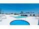 View of the community pool with lounge chairs and pool house at 10315 Cortez W Rd # 8Bv, Bradenton, FL 34210