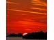 Beautiful sunset view with vibrant colors over the water and silhouetted landscape at 10315 Cortez W Rd # 8Bv, Bradenton, FL 34210