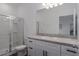 Bright bathroom featuring a shower, white cabinetry, and a granite countertop at 10459 Ladybug Cove, Parrish, FL 34219