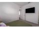A spare bedroom with carpet and a TV, next to an entrance to the bathroom at 10459 Ladybug Cove, Parrish, FL 34219