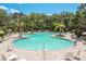 Expansive community pool surrounded by lounge chairs and lush landscaping, offering a perfect oasis for relaxation and recreation at 10459 Ladybug Cove, Parrish, FL 34219