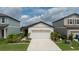 Charming single-story home with a pristine lawn and vibrant landscaping, featuring a two-car garage and modern facade at 10459 Ladybug Cove, Parrish, FL 34219
