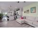Open-concept living space with modern gray flooring, a comfortable couch, and a view of the kitchen at 10459 Ladybug Cove, Parrish, FL 34219